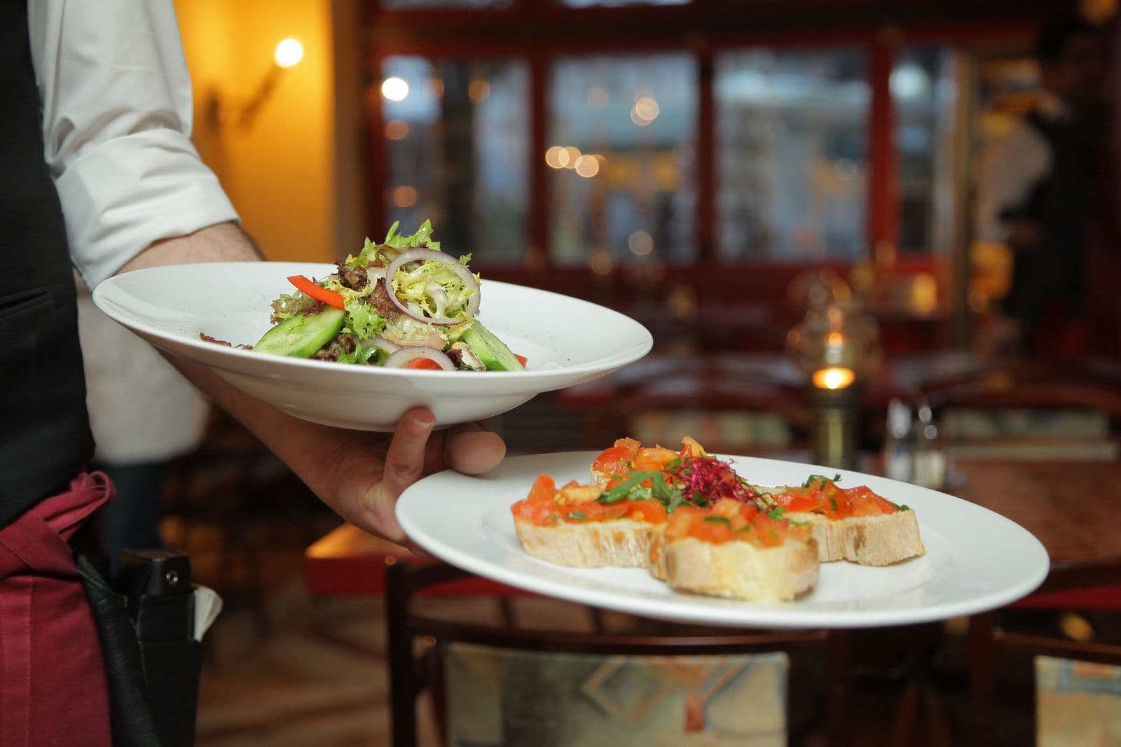 Server bringing plates out of the kitchen